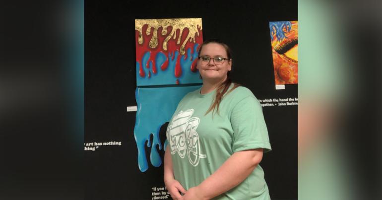 Glenville State University student Carla Bowman with some of the pieces that are on display as part of her Senior Art Show.