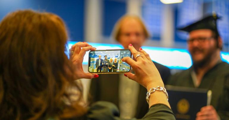 Glenville State University Dean of Education Connie Stout O’Dell takes a photo of a graduate and their family at Commencement in May 2022. The spring 2023 ceremony will take place on Saturday, May 6 at 10:00 a.m. (GSU Photo/Kristen Cosner)