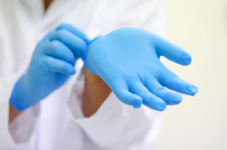 Doctor taking off gloves