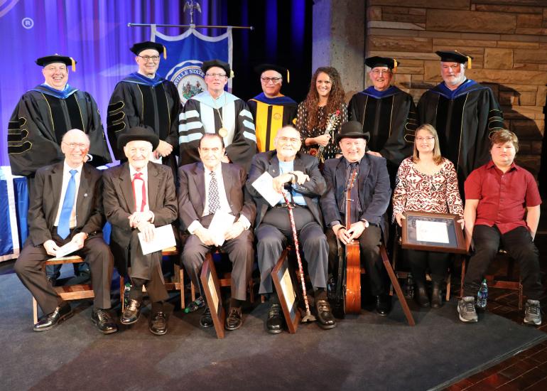 (seated, l-r) Buddy Griffin, Jesse McReynolds, Bobby Osborne, Sonny Osborne, Ronnie Reno accepting on behalf of Mac Wiseman, Jeanine McReynolds Reynolds and James Reynolds accepting on behalf of Jim McReynolds (standing, l-r) GSC Board of Governors Vice Chair Tim Butcher, GSC Board of Governors Member Mike Rust, GSC President Dr. Tracy Pellett, GSC Provost Dr. Victor Vega, GSC Bluegrass Music Program Director Dr. Megan Darby, GSC Board of Governors Member Dr. Bill Deel, GSC Board of Governors Chair Greg Smi