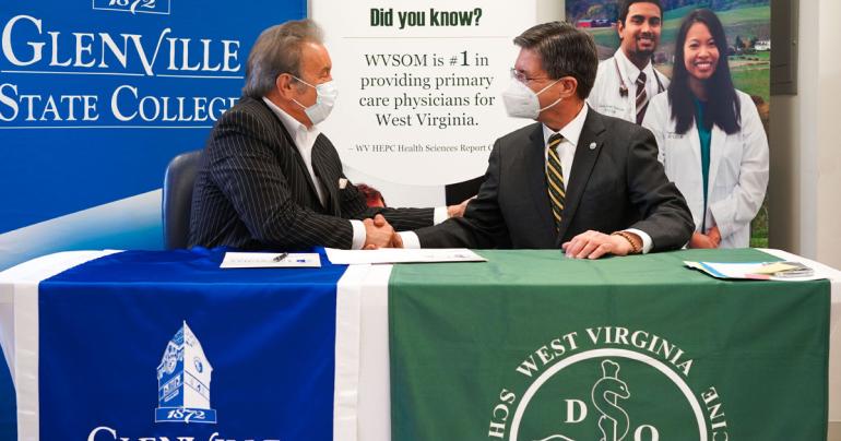 Glenville State University President Dr. Mark A. Manchin (left) and West Virginia School of Osteopathic Medicine President James W. Nemitz, Ph.D. shake hands following a recent signing ceremony welcoming Glenville State into the WVSOM Pre-Osteopathic Medicine Program. (GSC Photo/Kristen Cosner)