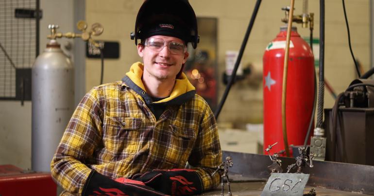 Glenville State College student Jesse Kargol with some of his welding designs (GSC Photo/Kristen Cosner)