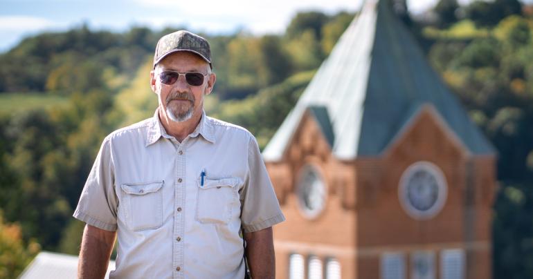 Glenville State University Trades Specialist Jim Tatman with the historic Administration Building Clock Tower behind him. (GSU Photo/Kristen Cosner)