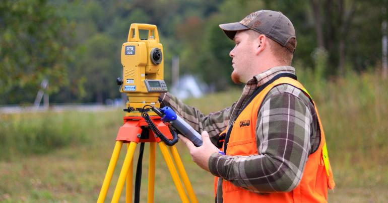 A former Glenville State University student uses land surveying equipment in the field. Graduates of the land surveying program are invited back to Glenville State for a reunion celebrating 50 years of the program. (GSU Photo/Kristen Cosner)