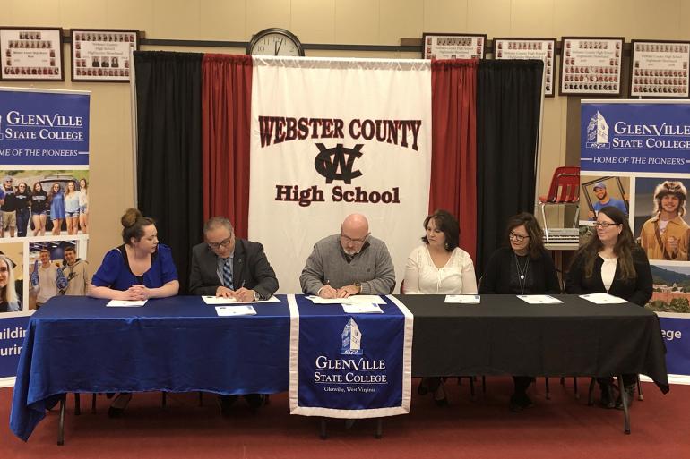 Glenville State College Provost Dr. Victor Vega (second from left) and Webster County School Schools Superintendent Scott Cochran (third from left) at the official signing ceremony