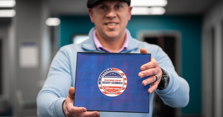 Glenville State University’s Veteran Certifying Official, Charles Yakubow, holds a badge recognizing Glenville State as a select Yellow Ribbon Program school. (GSU Photo/Kristen Cosner)